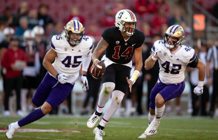 Oct 28, 2023; Stanford, California, USA; Stanford Cardinal quarterback Ashton Daniels (14) scrambles away from defensive pressure by Washington Huskies edge rusher Maurice Heims (45) and linebacker Carson Bruener (42) during the first quarter at Stanford Stadium.